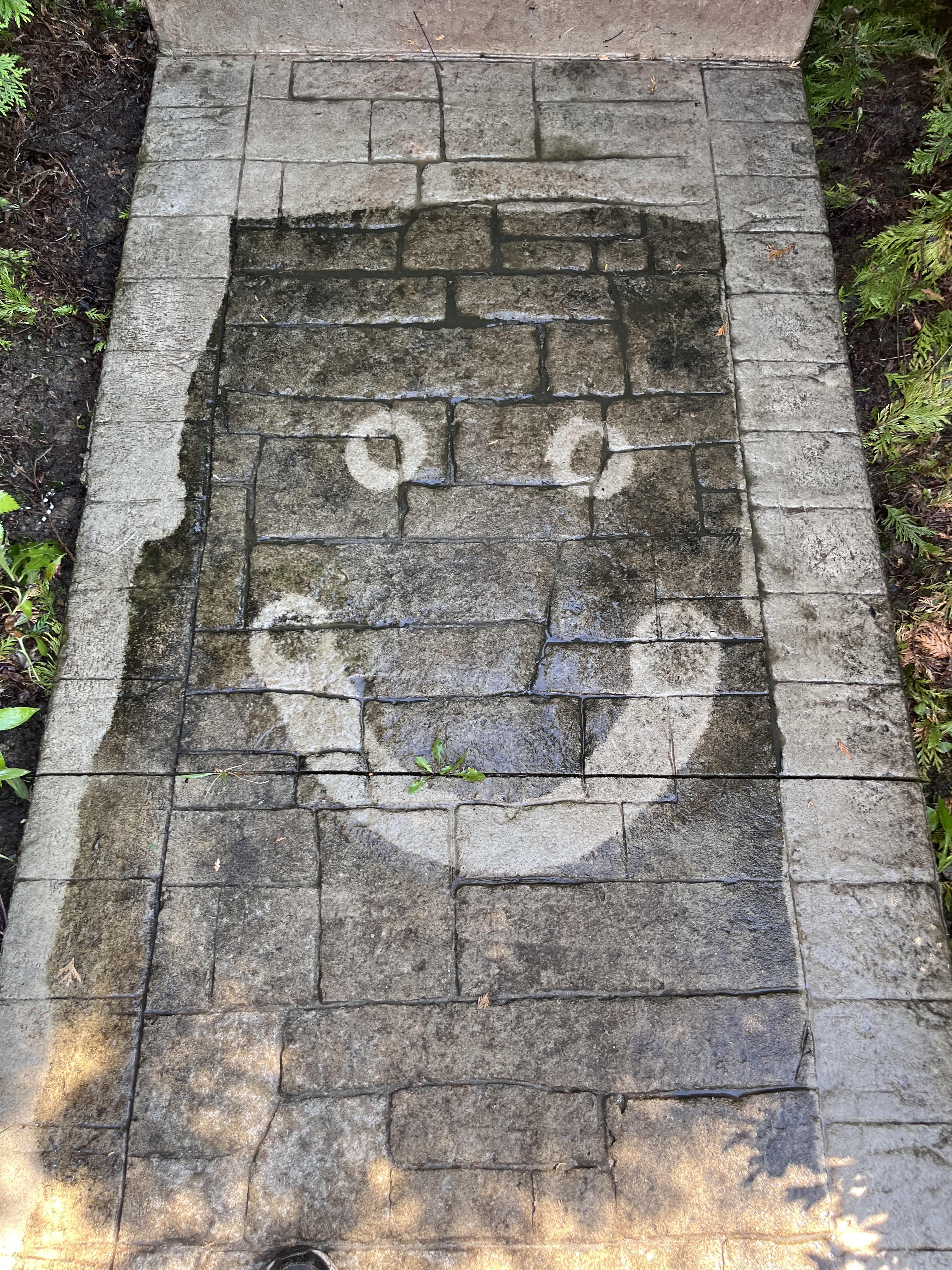 NeighborWash pressure washing creates a smiley face on patio - precision cleaning with personality